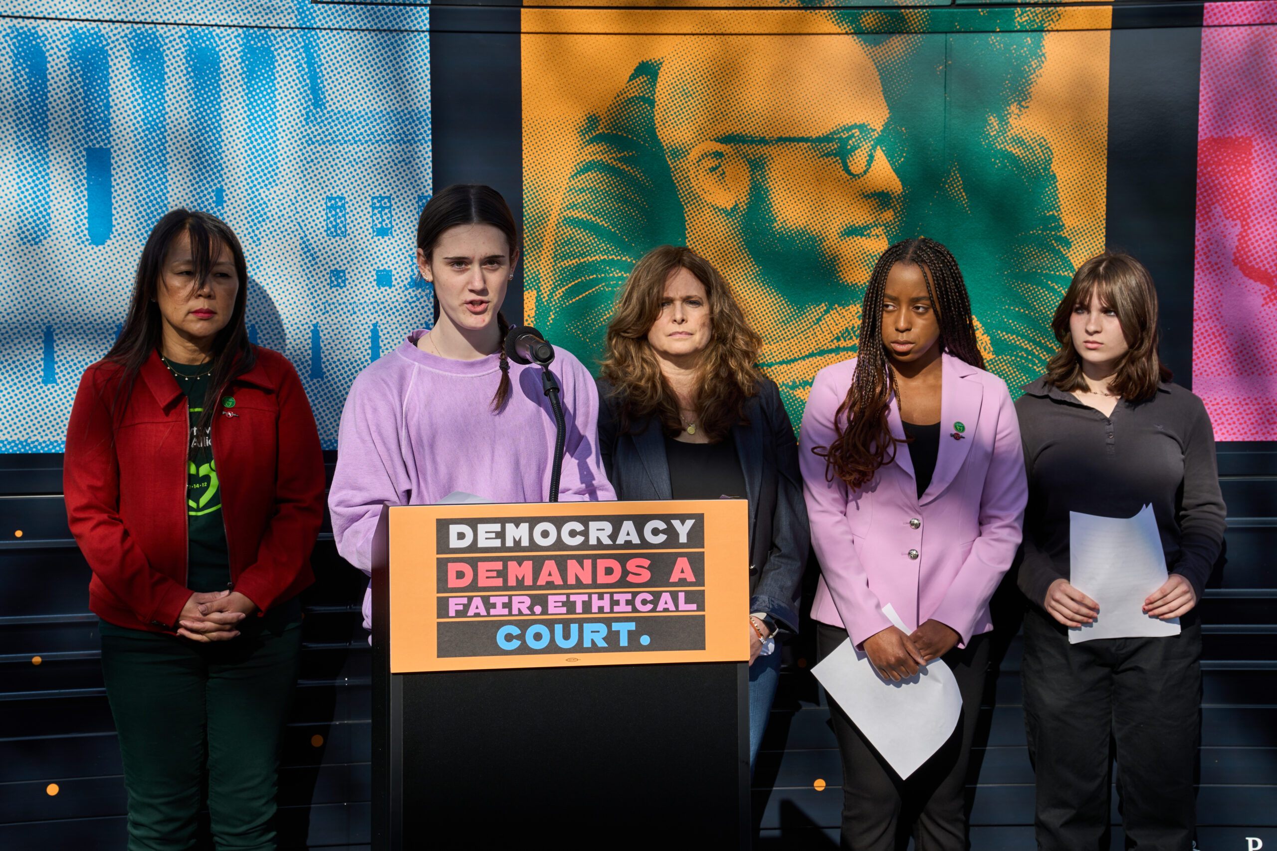 image of sandy hook survivors speaking behind a podium at a press event